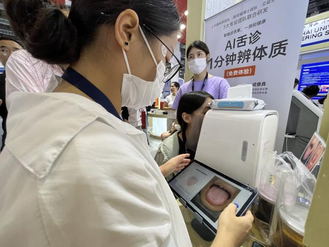 觀展者在體驗“AI舌象儀”舌診